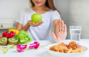 close-up-young-asian-woman-using-hand-push-out-her-favourite-fried-chicken-french-fries-choose-green-apple-fruit-vegetables-good-health-woman-dieting-concept-close-up_164138-700